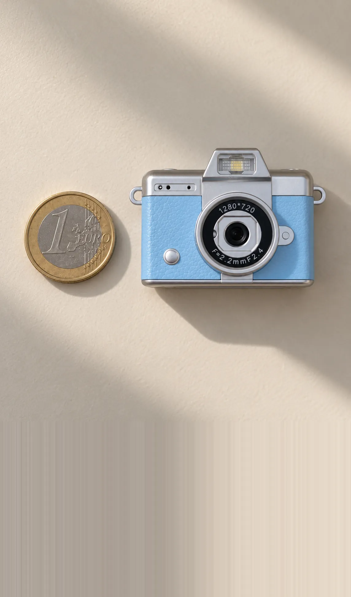 La Cámara Mini azul vista desde arriba junto a una moneda de un euro, apenas dos veces más ancha que la moneda